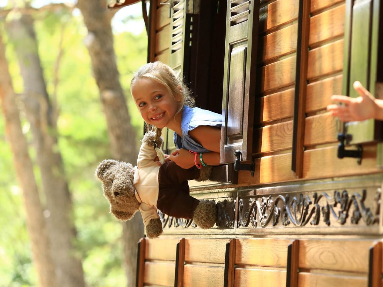 Happy child holding a stuffed toy at Domaine de Manville