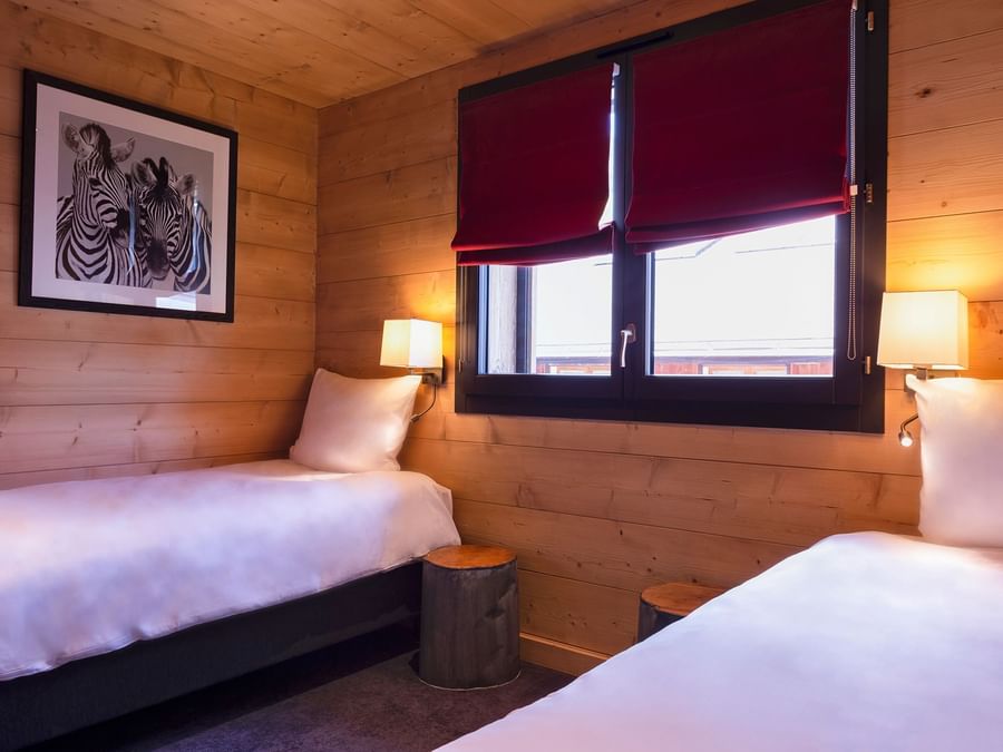 Two single beds in the bedroom at Chalet Hotel La Marmotte