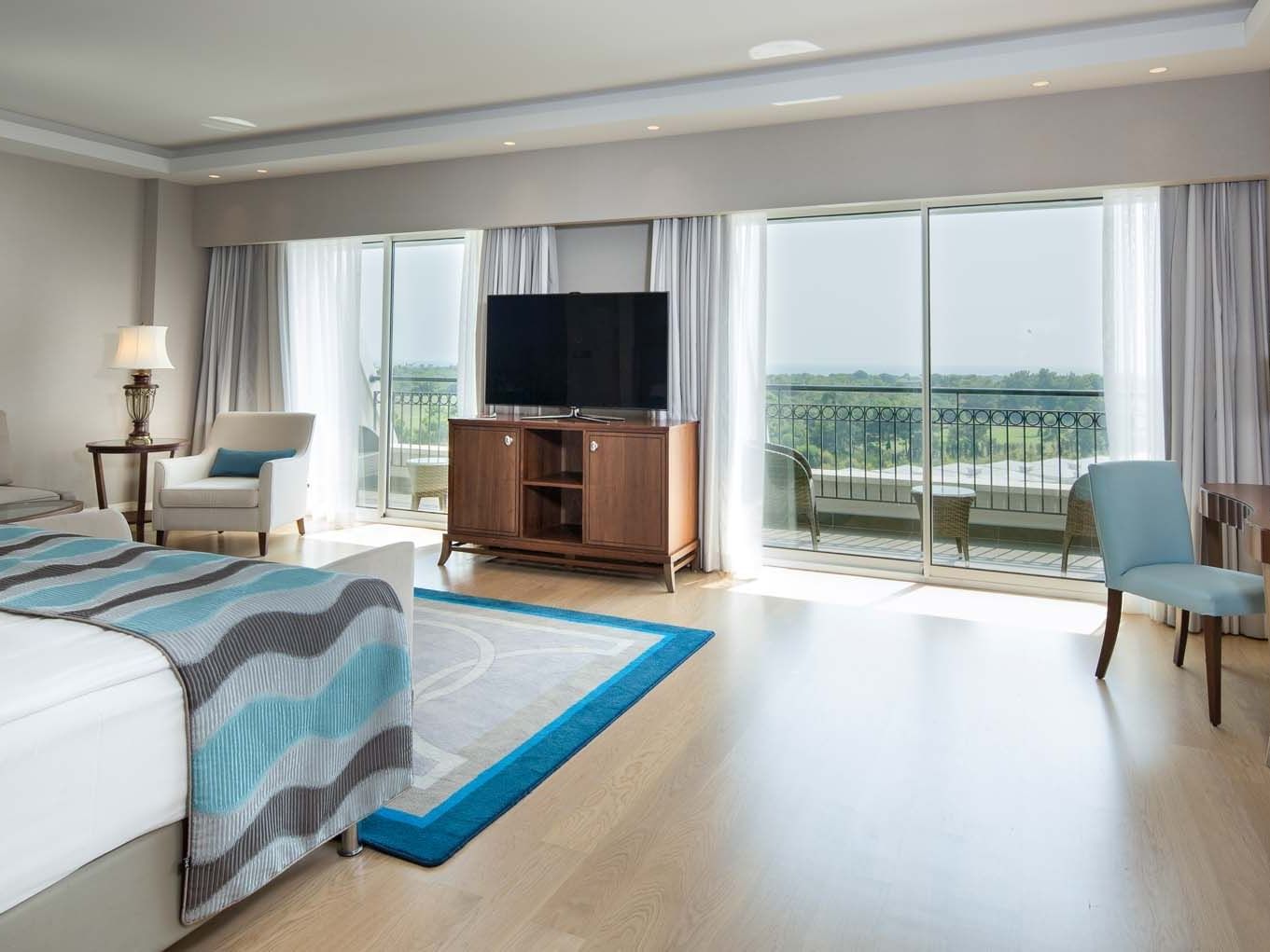 TV facing the bed in Deluxe Room with wooden floors at Titanic Deluxe Golf Belek