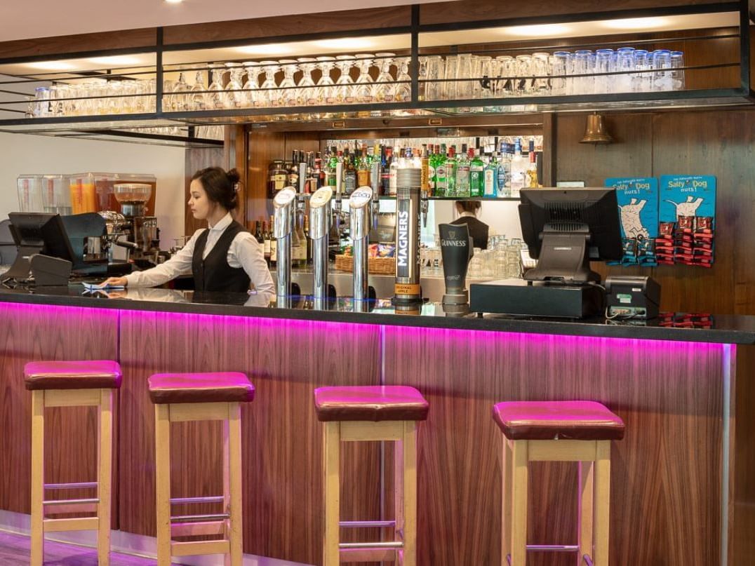 Bar counter with bar chairs in Hugo’s Bar at St. Giles Heathrow