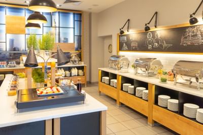 Restaurant interior with large windows and food counter in Metropol Hotel Warsaw Restaurant & Bar at Metropol Hotel