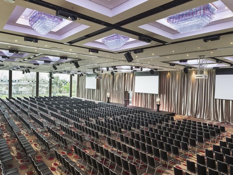 Theatre set-up in Grand Ballroom with screens and carpeted floors at Pullman Albert Park