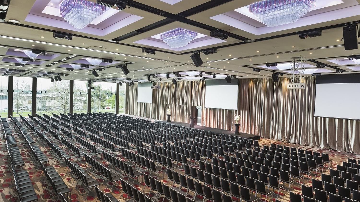 Theatre set-up in Grand Ballroom with screens and carpeted floors at Pullman Albert Park