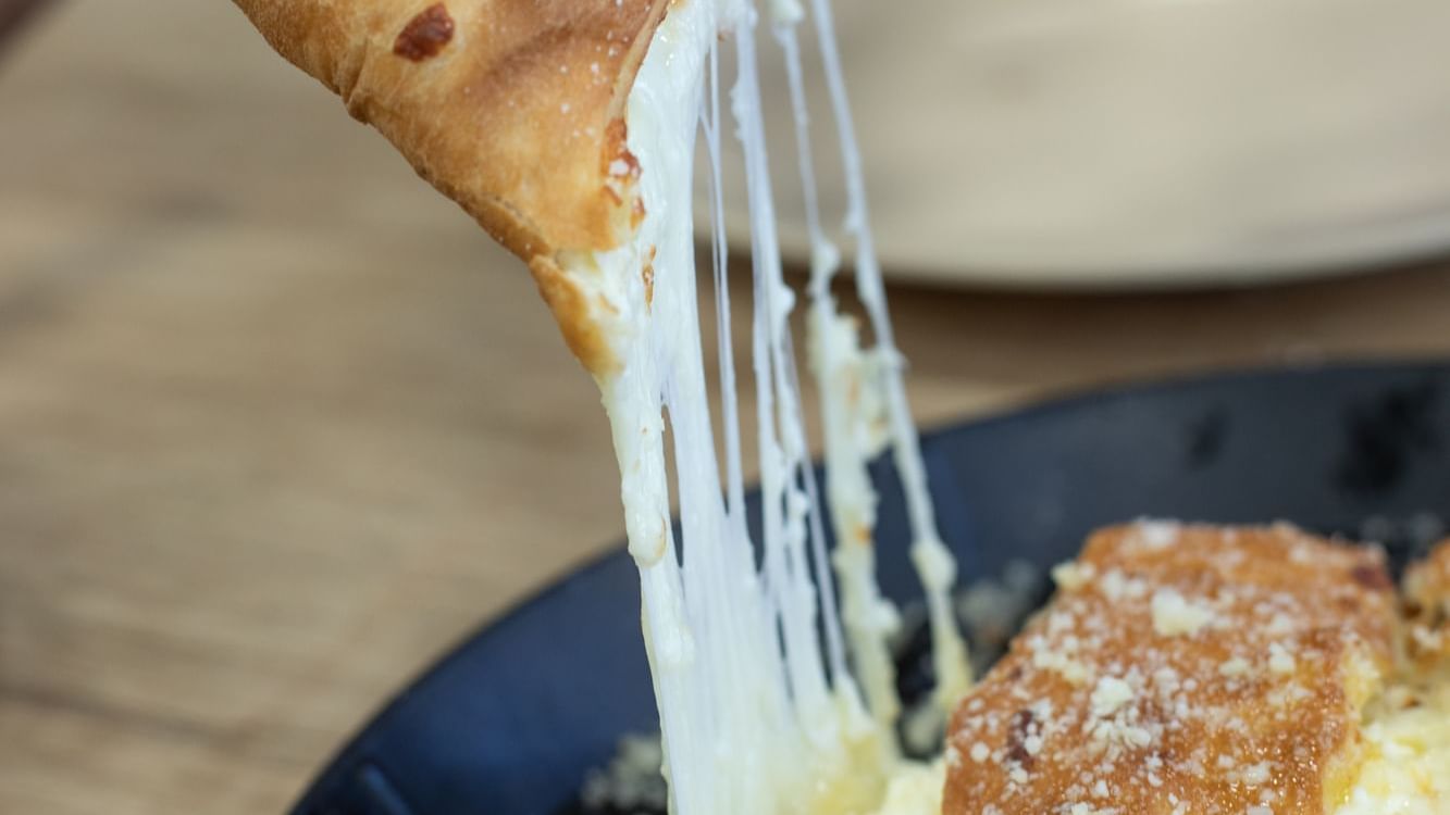 Close-up of a plate with cheesy inside pizza in Bruno’s Pizza at Watersound Inn
