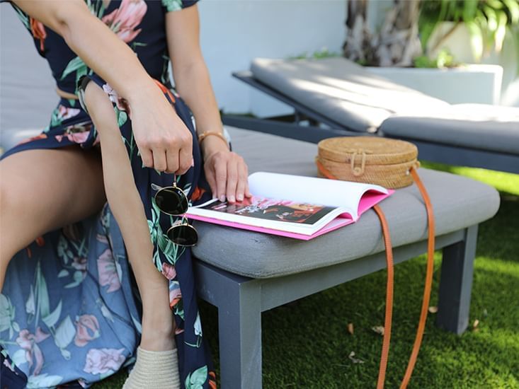 A lady on a lounge chair reading a book at South Beach Hotel