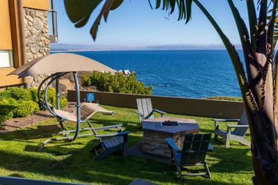Swing chair on grass facing the ocean