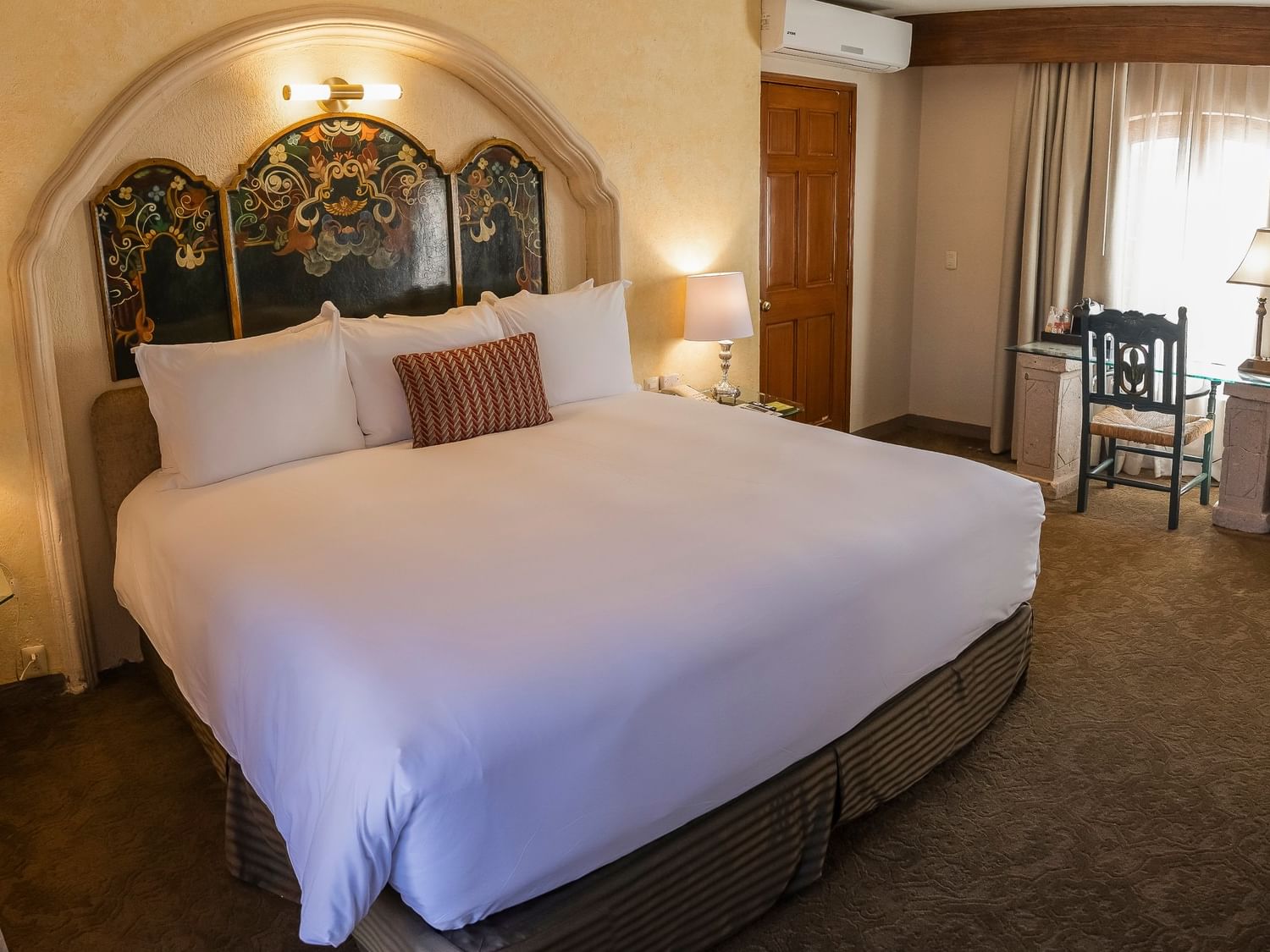 King Presidential Suite with ornate headboard, white linens, and seating area at Quinta Real Zacatecas