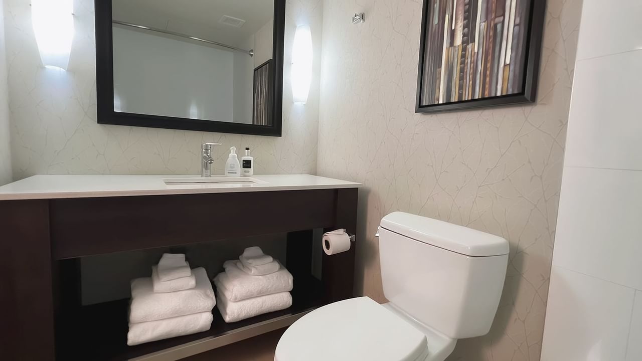 Bathroom with towels, toilet, mirror, sink