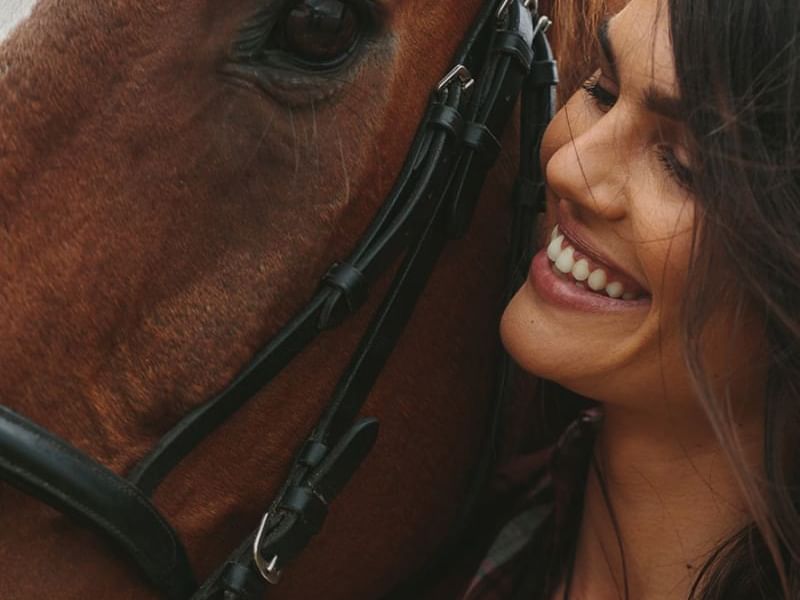 acercameinento de mujer sonriendo con caballo