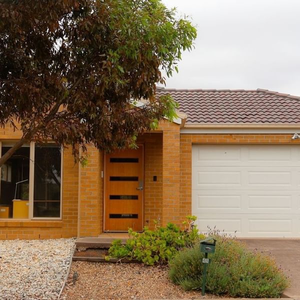 Modern yellow brick house with garage and driveway at La Trobe University Regional Housing – Melton.