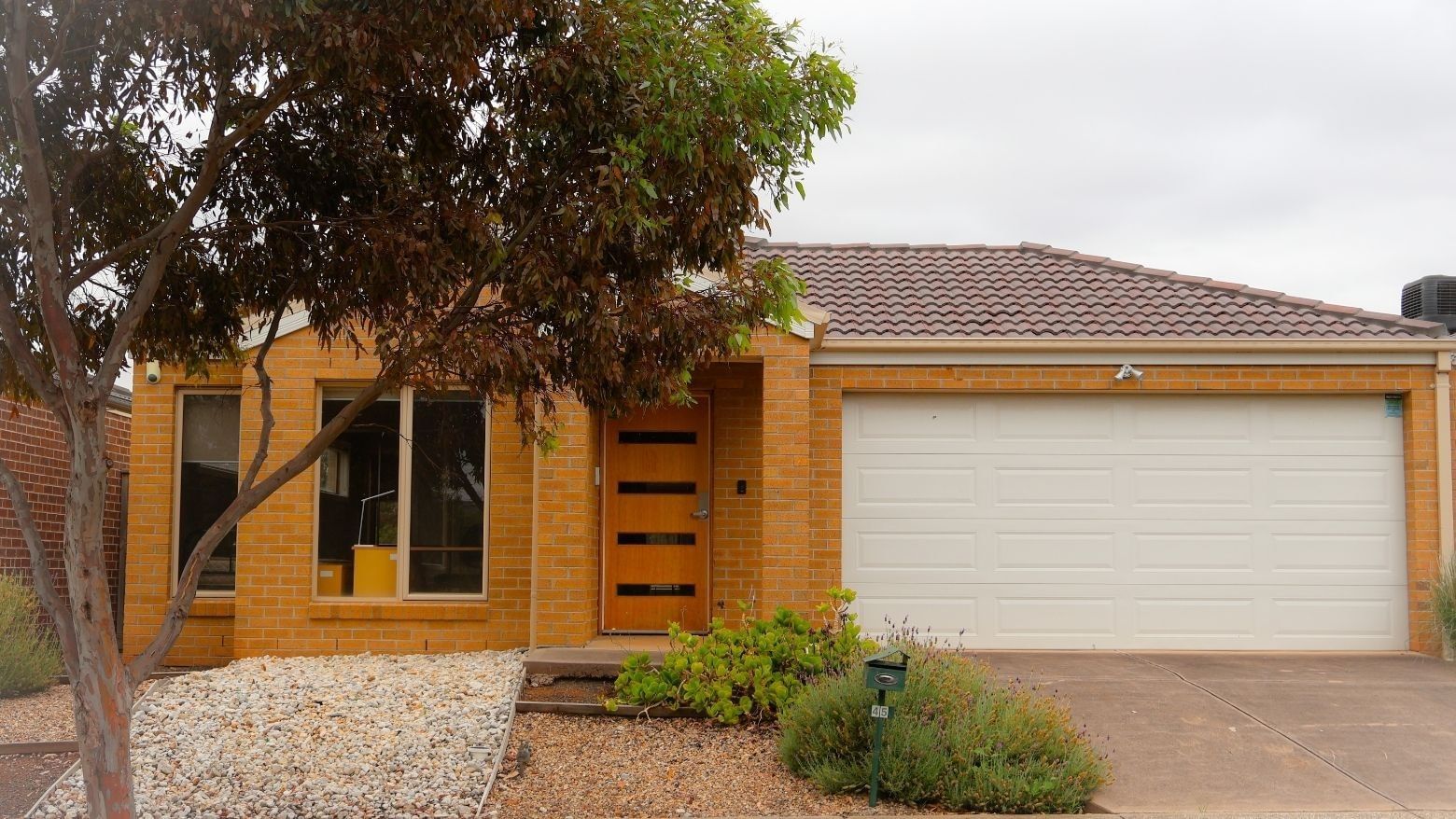 Modern yellow brick house with garage and driveway at La Trobe University Regional Housing – Melton.