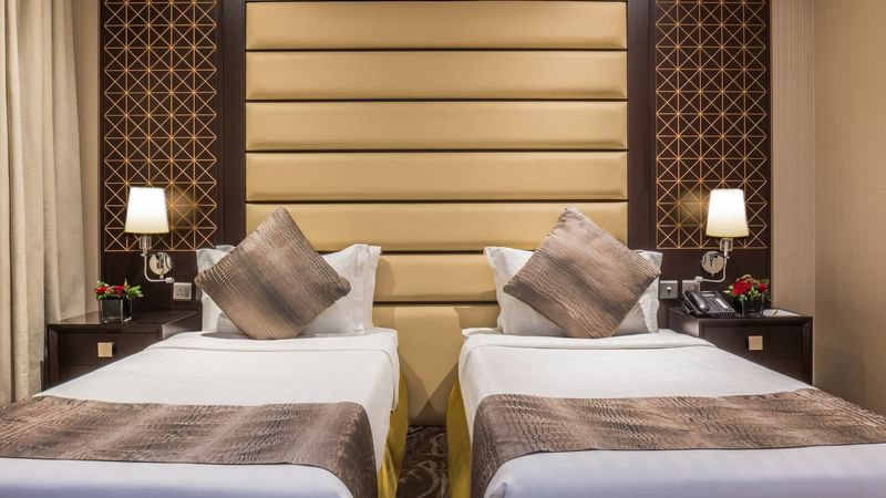 Two beds with nightstands in Standard Twin Room at Warwick Hotels & Resorts
