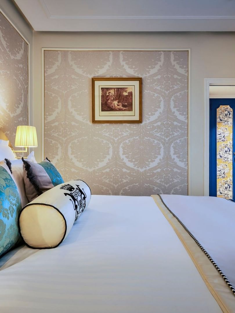 Élégante chambre Deluxe avec un grand lit, du papier peint à motifs et une vue sur Paris à l'Hôtel Westminster - Paris.