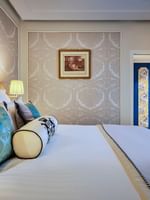 Élégante chambre Deluxe avec un grand lit, du papier peint à motifs et une vue sur Paris à l'Hôtel Westminster - Paris.