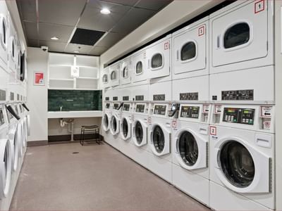 Laundry room with multiple washing machines and dryers at Mayoral Drive Student Accommodation.