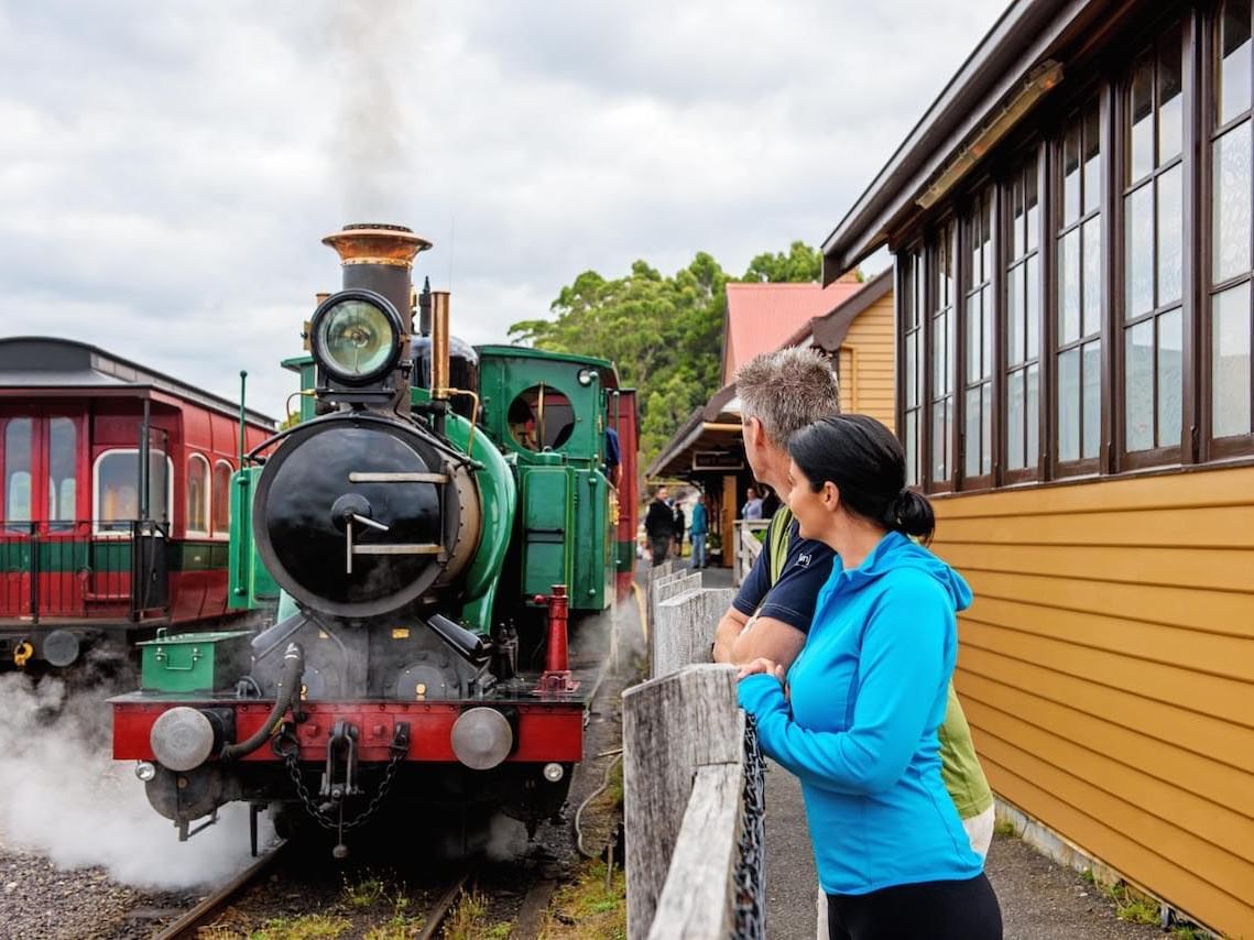 Couple watching the trains in the station near Strahan Village