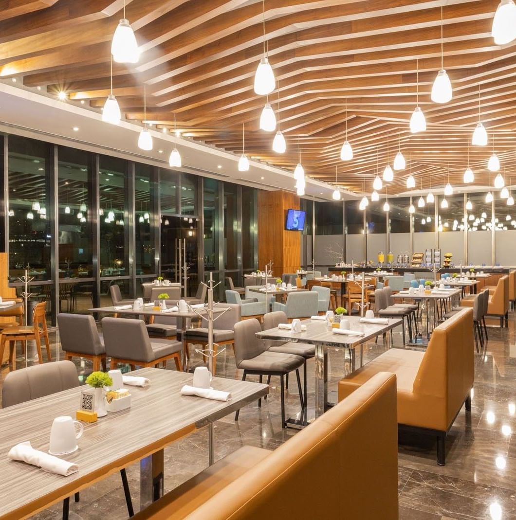 Distrito Regio room with tan booth seating and large windows showing the city at Camino Real Fashion Drive, Monterrey