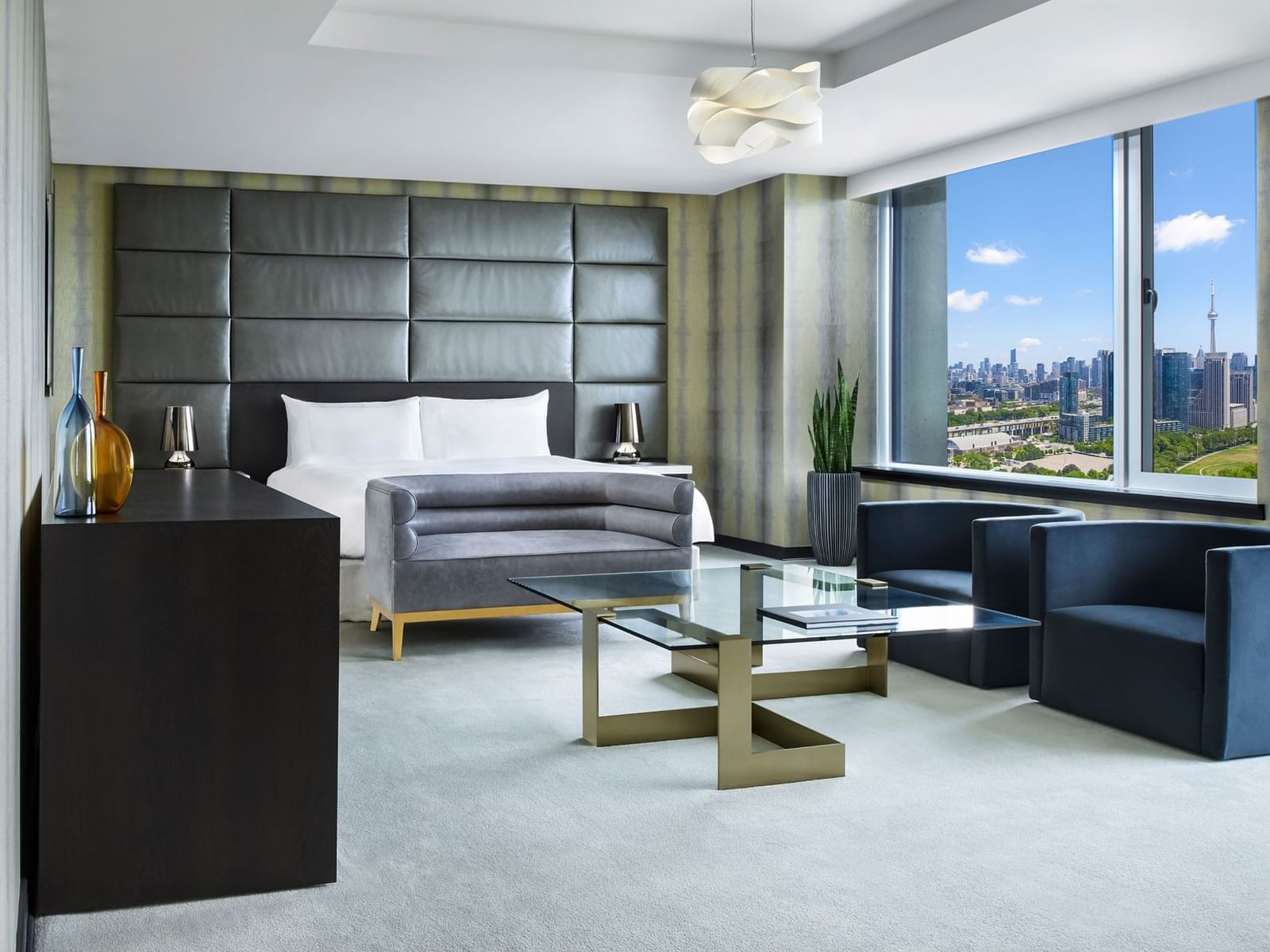 Bed and living area with city view in Presidential Suite, Toronto hotel suites at Hotel X Toronto