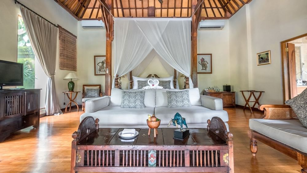 Chambre luxueuse dotée d'un haut plafond en bois et d'un lit à baldaquin orné de draperies blanches au TokaToka Resort Nadi, aux Fidji