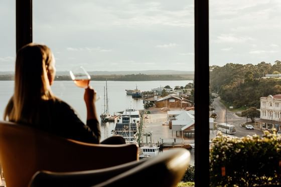 Lady sipping on wine while enjoying the lake view at Freycinet Lodge