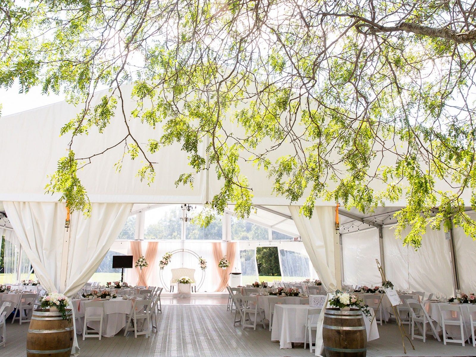 Spencer Meadows Pavilion decorated for dining and ceremony with a floral arch at Spencer Hotel & Conference Centre