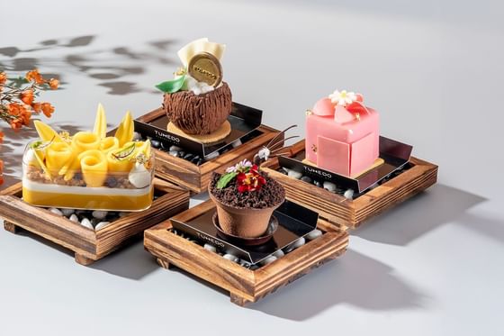 Luxury sweet desserts displayed on wooden boards at Carlton Hotel Bangkok Sukhumvit