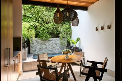 Chic dining area with a view of a small jacuzzi and lush green plants in Casa Cielo at Singular Signature Residences
