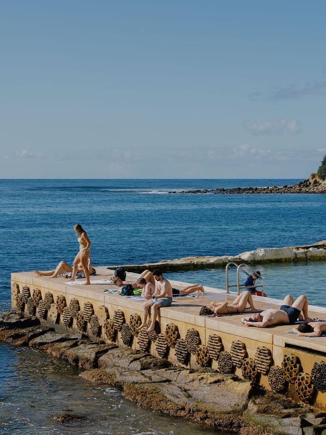 Fairy Bower Sea Pool at Elysium Hotels beside people sunbathing on concrete platform, capturing iconic things to do in manly