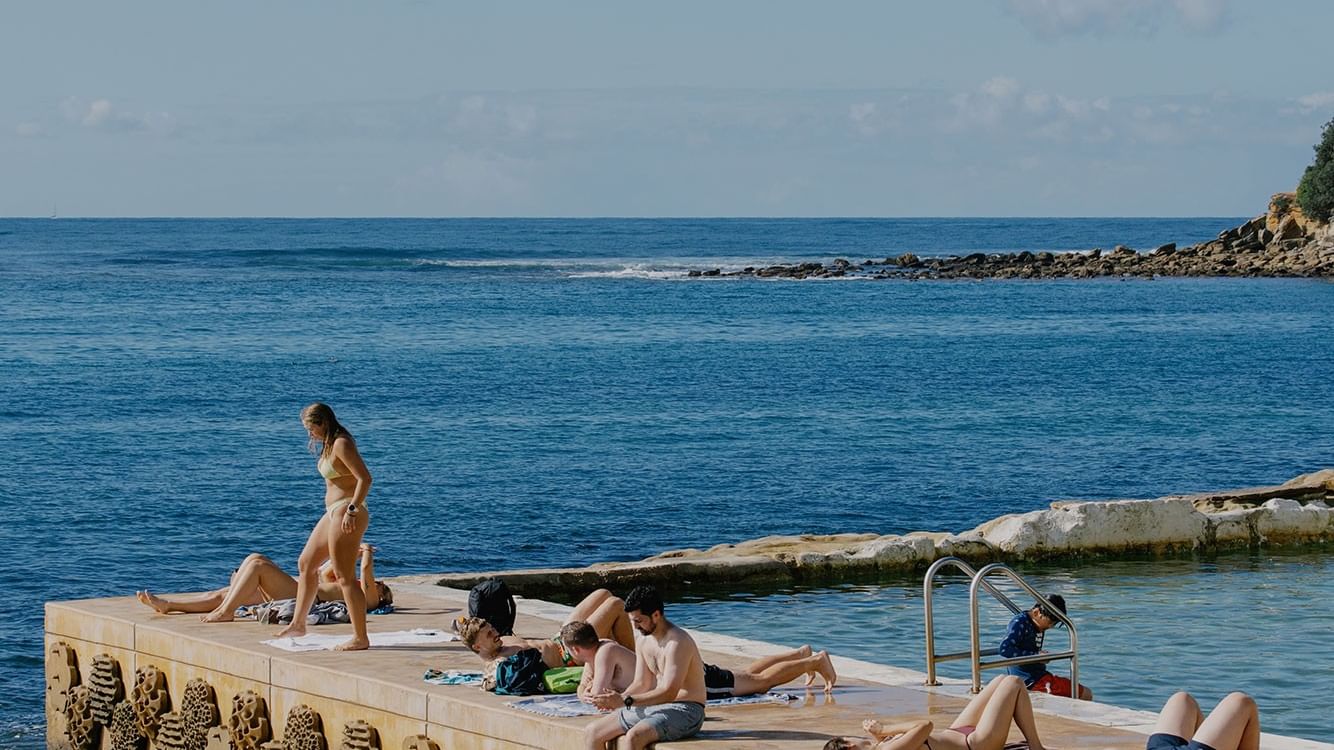 Fairy Bower Sea Pool at Elysium Hotels beside people sunbathing on concrete platform, capturing iconic things to do in manly