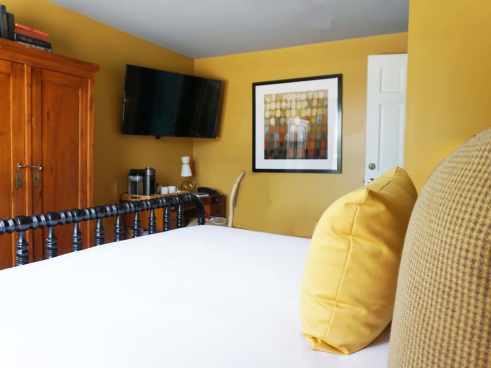 Cozy bedroom with yellow walls and bed at The Clifton in Charlottesville.