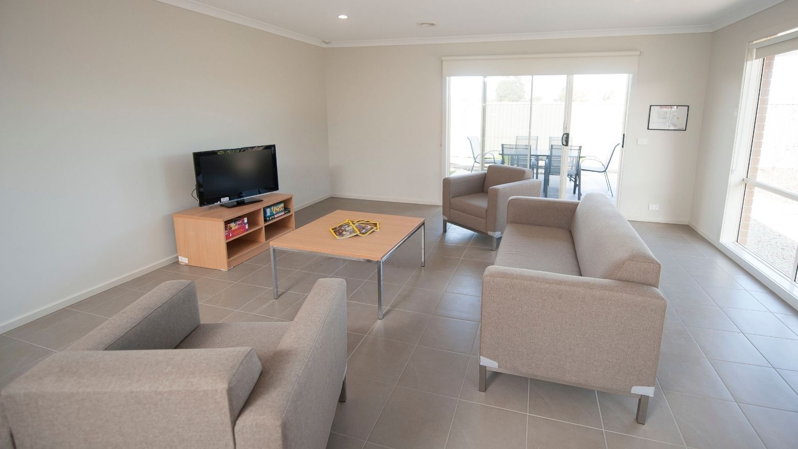Living room with couch, TV, and table at La Trobe University Regional Housing – Shepparton.