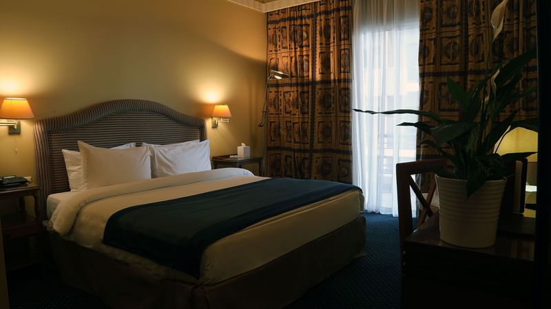 King bed by a window in Junior Suite Bedroom at Warwick Palm Beach Hotel - Beirut