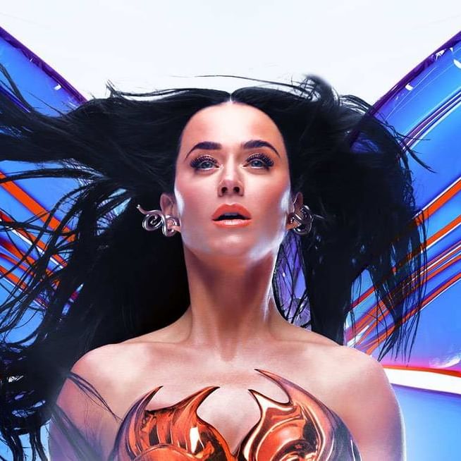 Katy Perry performing live on stage in a vibrant outfit with fireworks and neon lights in the background
