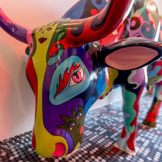 Closeup of a rainbow cow sculpture at Retro Suites Hotel