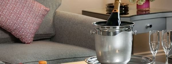 In-Room Dining with Wine in a bucket by treats under a lamp at Warwick Melrose Dallas