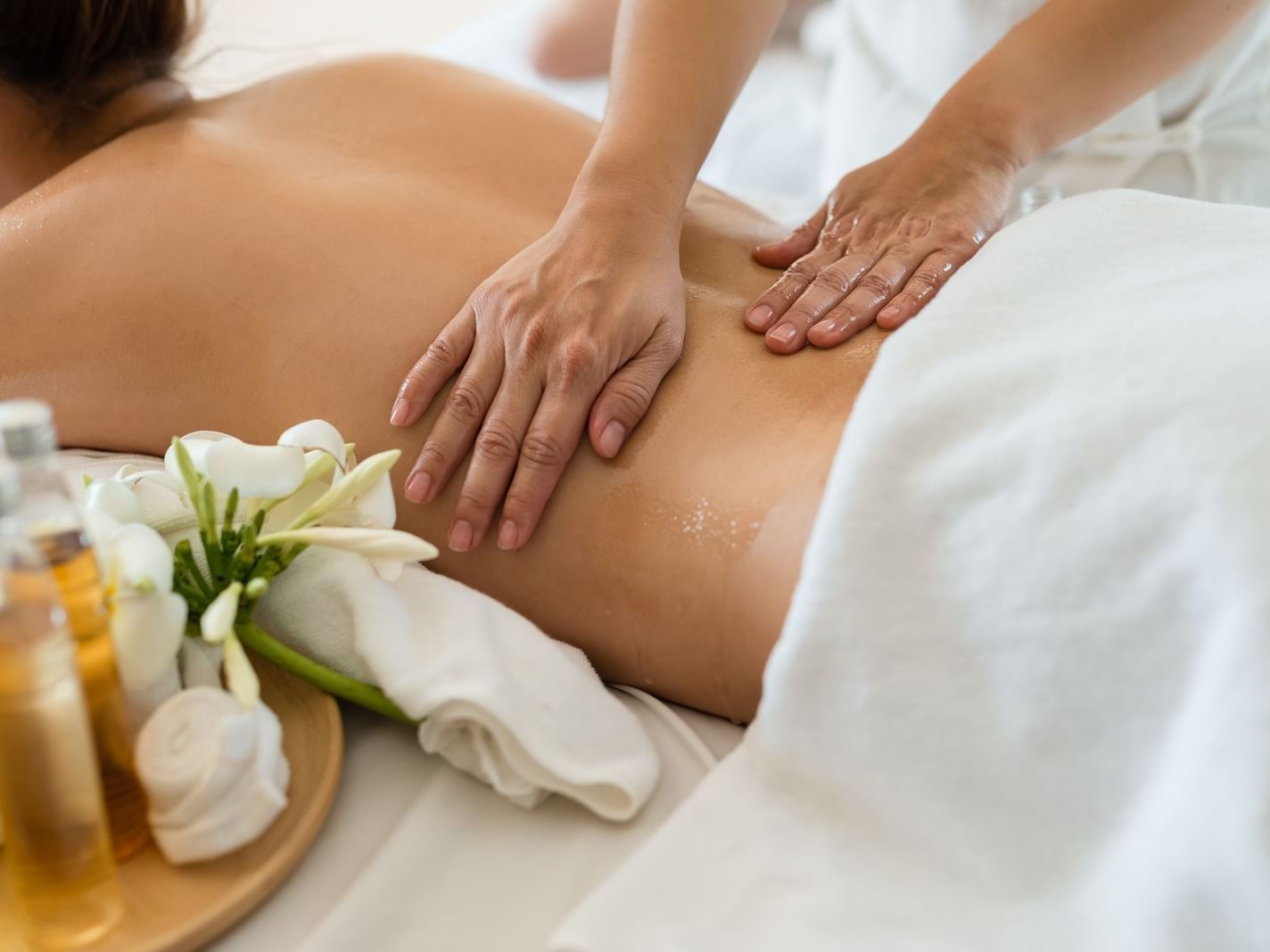 A lady receiving a body massage in the spa at La Colección