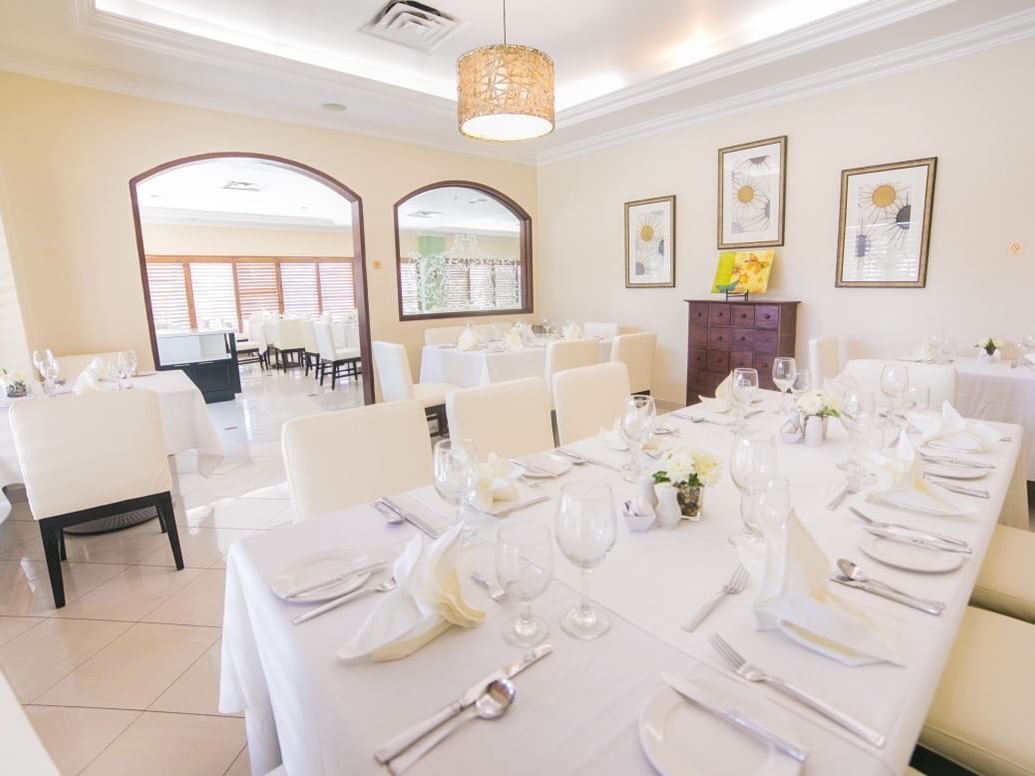 Chairs surrounding set tables under lamps in Alexander\’s Restaurant at Courtleigh Hotel & Suites, new Kingston restaurants