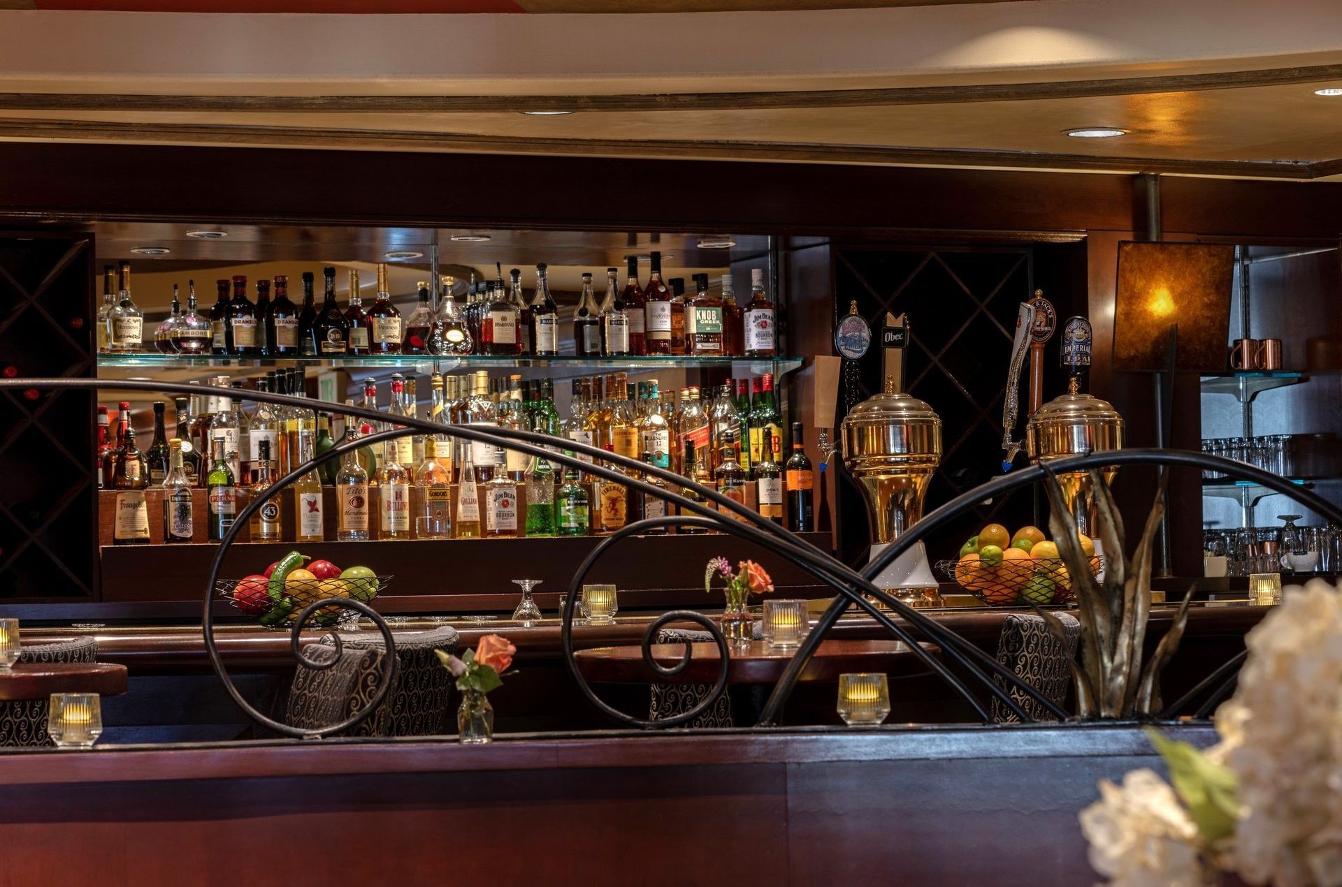 Margaux Lounge Bar featuring beer taps by shelves of liquor bottles behind a decorative rail at Warwick Seattle