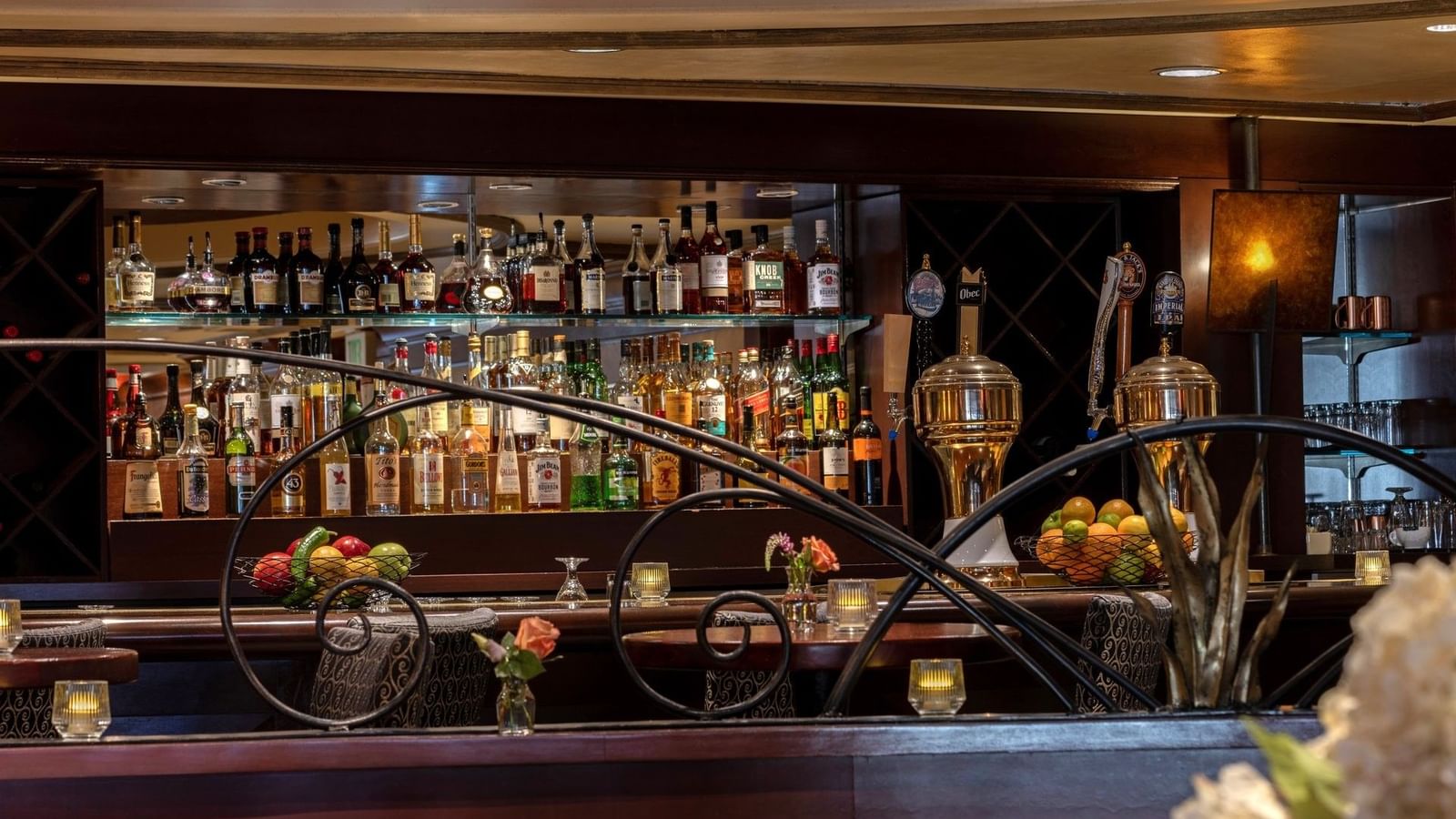 Margaux Lounge Bar featuring beer taps by shelves of liquor bottles behind a decorative rail at Warwick Seattle