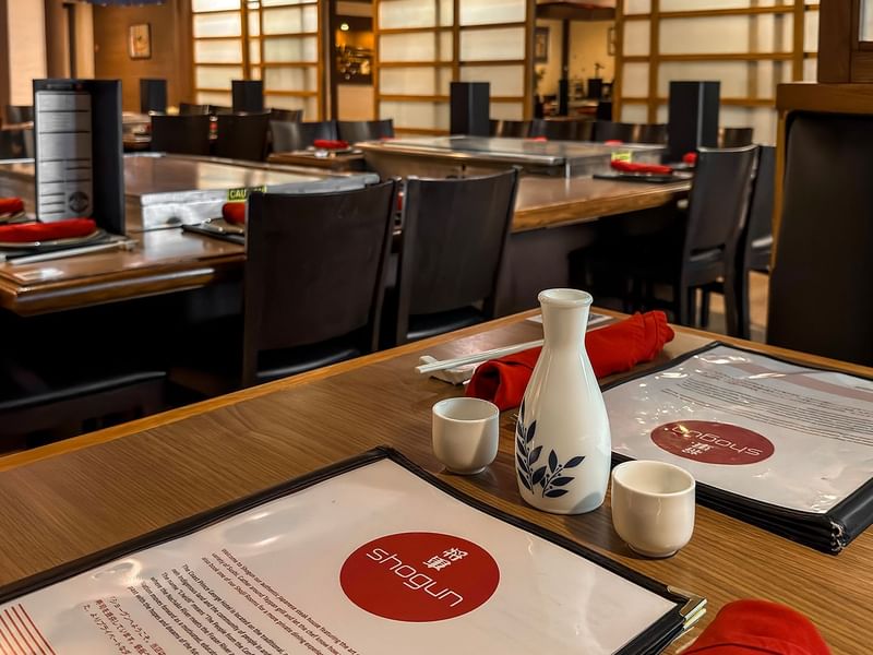 Restaurant with several tables, each set with a menu.