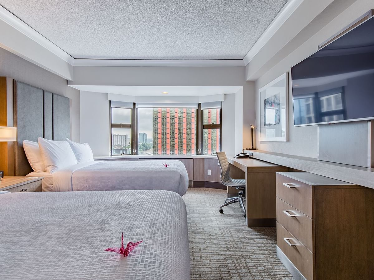 Hotel guestroom with two beds, TV and desk