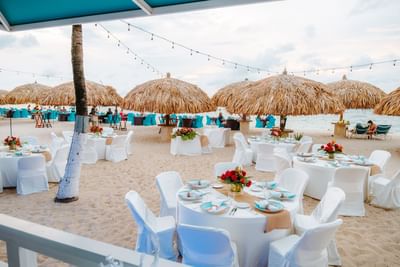Beachside dining area with thatched umbrellas at Passions on the Beach