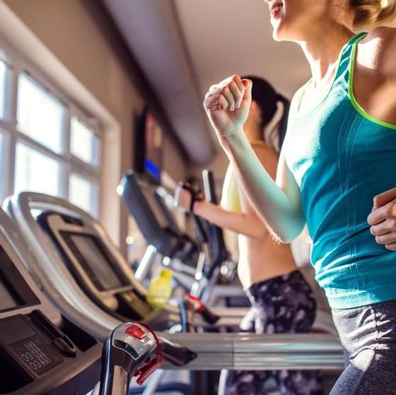 Two women running on treadmills in the gym at Haven Riviera Cancun