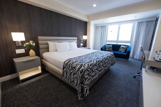 Comfy bed with side table and couch in a room at Jamaica Pegasus Hotel