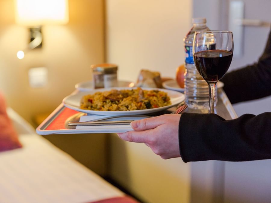 A waiter serving food at Hotel qualys reims tinqueux