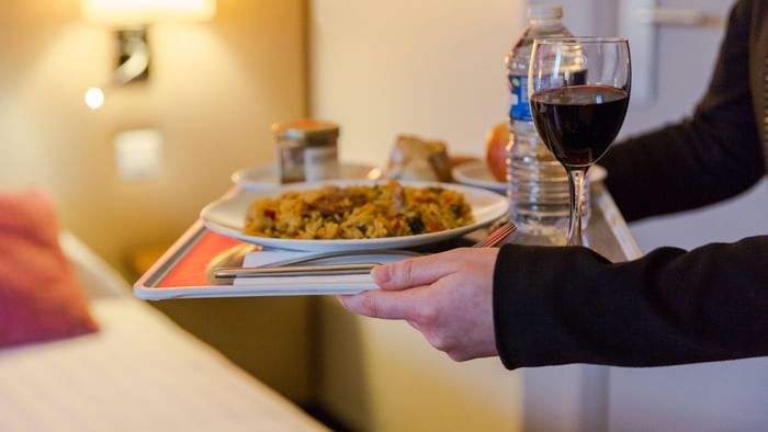 A waiter serving food at Hotel qualys reims tinqueux