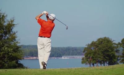 man golfing in orange polo