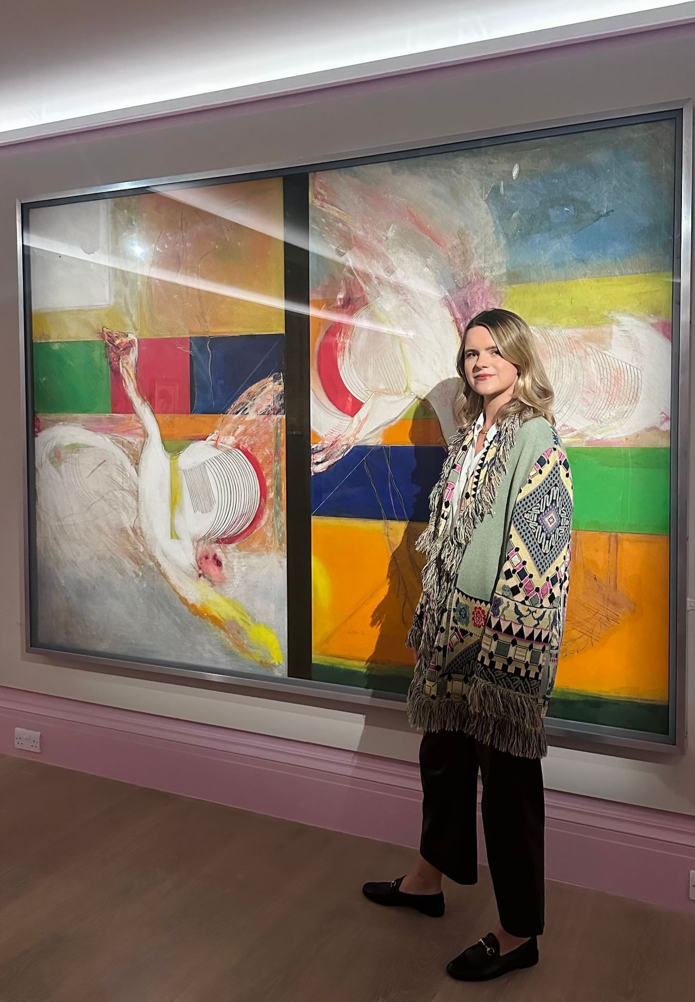 Woman posing in front of a vibrant artwork at the Royal Academy of Arts located near The Londoner Hotel