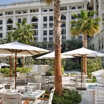 Outdoor dining area with huts & palm trees at Palazzo Versace