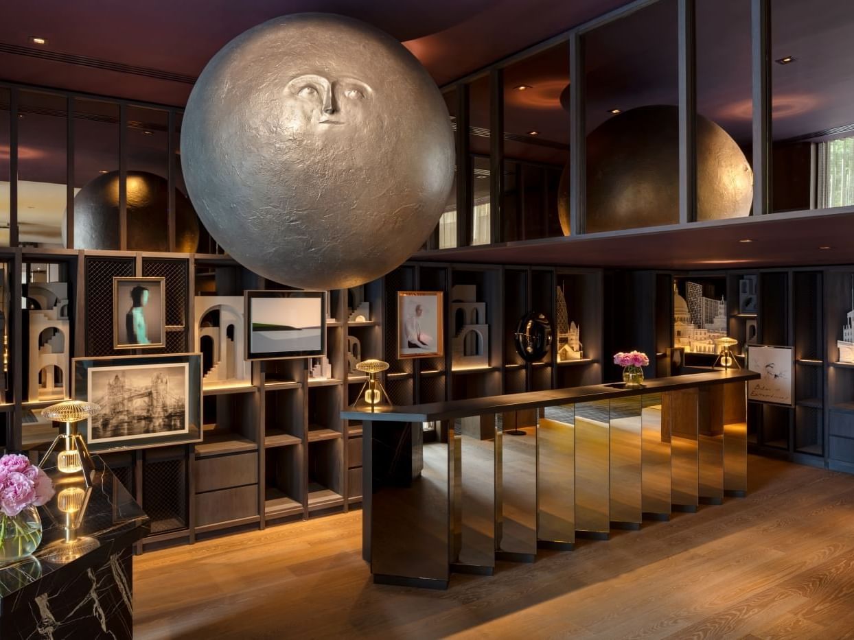 Andrew Rae's Moonhead sculpture suspended above reception at The Londoner hotel.